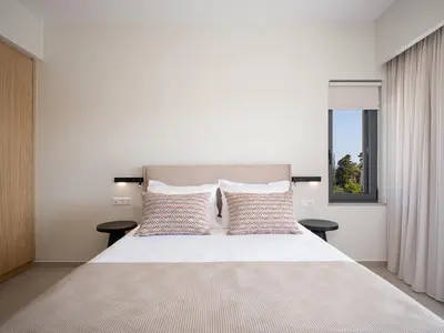 a bedroom with a large white bed with two tables at Villa Thimi - Luxury Family Villa - Private Pool in Korakiaí