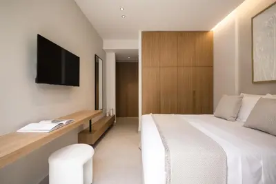 a bedroom with a bed and a desk with a tv at Memoire Guest House I Private Heated Pool I 200m beach in Chania Town
