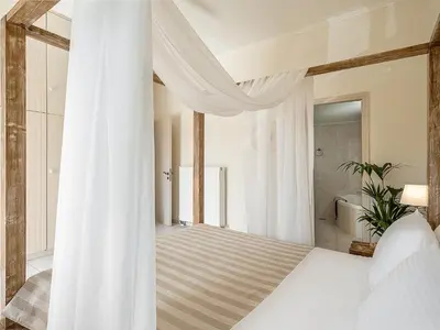 a bedroom with a bed with white curtains at Villa Crista in Áptera