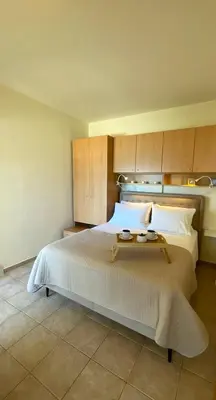 a bedroom with a large white bed with wooden cabinets at Azzurro in Stalos