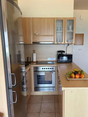 a kitchen with a refrigerator and a plate of fruit at Azzurro in Stalos