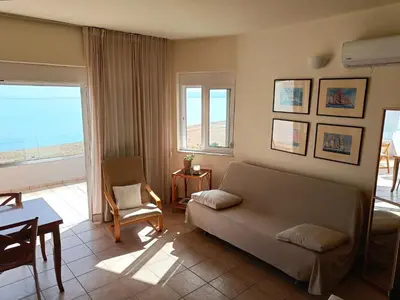 a living room with a couch and a view of the ocean at Azzurro in Stalos