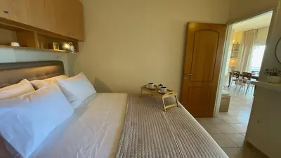 a bedroom with a white bed with a wooden headboard at Azzurro in Stalos