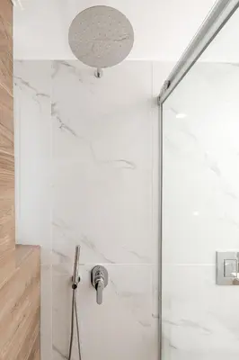 a shower in a bathroom with white marble walls at Artemis Apartments in Chania Town