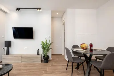 a dining room with a table and chairs and a tv at Artemis Apartments in Chania Town