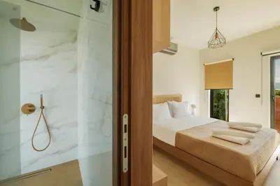 a bedroom with a bed and a glass shower at Madre Tierra Boutique Villa 2 in Liyidhés