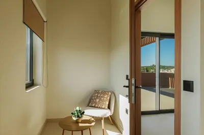 a room with a chair and a table and a door at Madre Tierra Boutique Villa 2 in Liyidhés