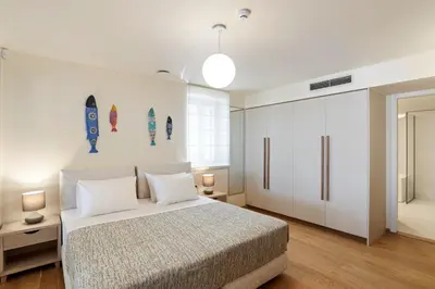 a bedroom with a bed and two surfboards on the wall at Kormoranos-Hydrobates Waterfront Villa in Chania Town