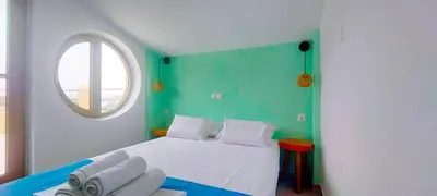 a bedroom with a white bed and a window at Umoya in Palaiochóra