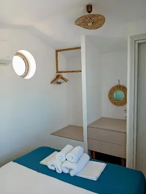 a bedroom with towels on a bed with a mirror at Umoya in Palaiochóra