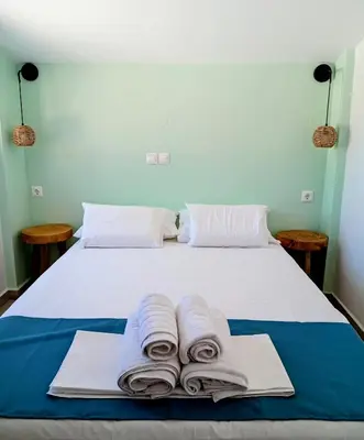 a bed with towels sitting on top of it at Umoya in Palaiochóra