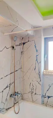 a shower in a bathroom with a marble wall at Umoya in Palaiochóra