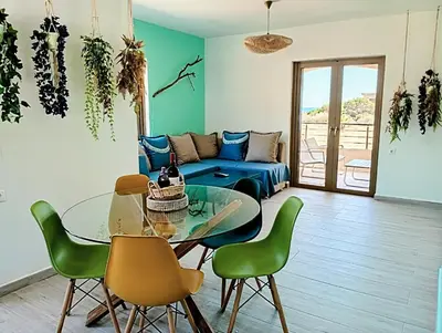 a living room with a blue couch and a glass table at Umoya in Palaiochóra