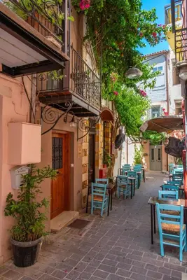 an alley with blue chairs and tables and a balcony at Mythos -Old Town-Old harbour Chania in Chania Town