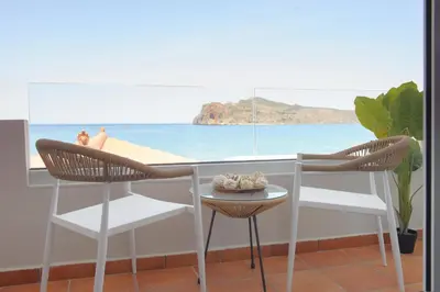 a table and chairs in a room with a view of the beach at Stavros Beachfront Suites in Agia Marina Nea Kydonias