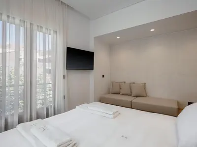 a white room with two beds and a couch at KT Suites in Chania Town