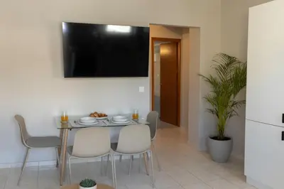a dining room with a table and chairs and a television at kolymvari4you in Kolymvari