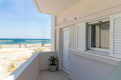 a white house with a window and the beach at kolymvari4you in Kolymvari