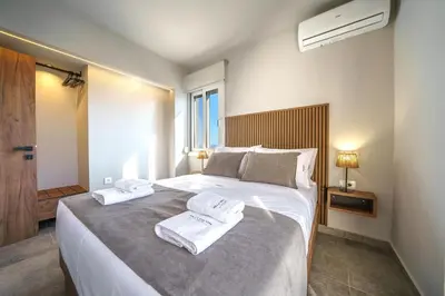 a bedroom with a large bed with towels on it at Villa ViKaDa in Stalos