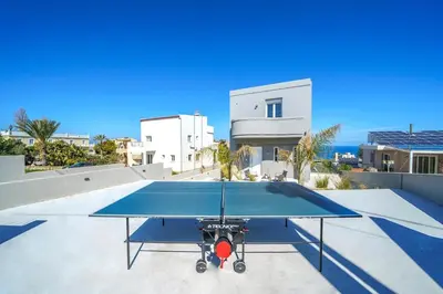 a ping pong table on the roof of a house at Villa ViKaDa in Stalos