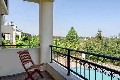 a room with a balcony with a chair and a view at Theodoras Villas in Gavalochori