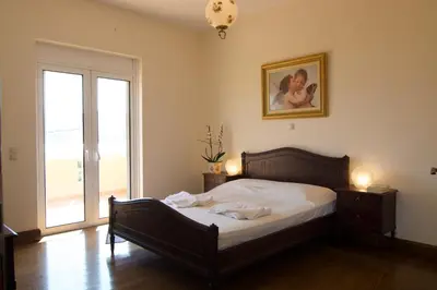 a bedroom with a bed and a large window at Villa Ektor in Kissamos