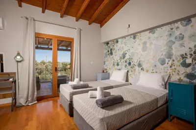 a bedroom with two beds and a balcony at Zen Maisonette Retreat in Daratso
