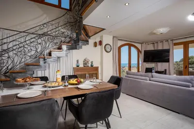 a dining room with a table and a staircase at Zen Maisonette Retreat in Daratso