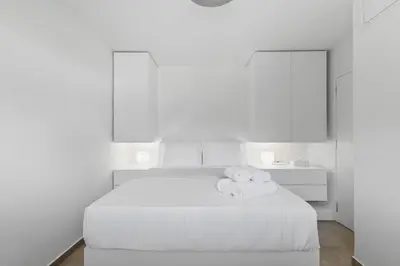 a white bedroom with a white bed with towels on it at 6622 Luxury Apartment with Shared Pool in Chania Town