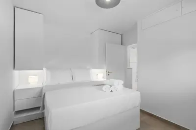 a white bedroom with a bed with towels on it at 6622 Luxury Apartment with Shared Pool in Chania Town