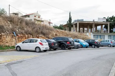 a row of cars parked in a parking lot at Kamari Apartment - Chania in Chania Town