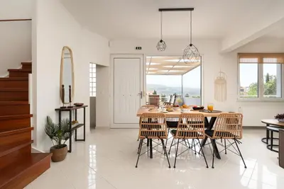 a kitchen and dining room with a table and chairs at Pithos Apartment in Korakiaí