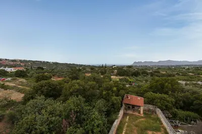 an old building on top of a hill with trees at Pithos Apartment in Korakiaí