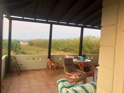 a screened in porch with a table and chairs at Solar Retreat Maleme in Maleme