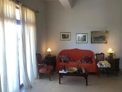 a living room with a red couch and a table at Solar Retreat Maleme in Maleme