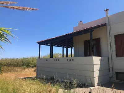 a small white house with a roof on a field at Solar Retreat Maleme in Maleme