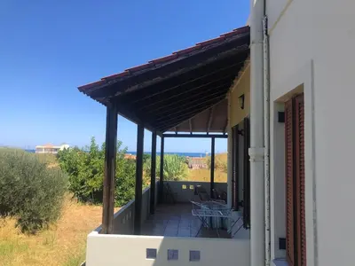 a porch of a house with a roof at Solar Retreat Maleme in Maleme