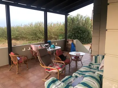 a screened in porch with chairs and a table at Solar Retreat Maleme in Maleme
