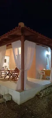 a pavilion with a table and chairs on a patio at casa di Beatrice in Georgioupolis