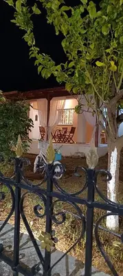 a black fence with a tree in front of a house at casa di Beatrice in Georgioupolis