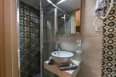 a bathroom with a sink and a shower at Jasmine Studio - at the heard of old town in Chania Town