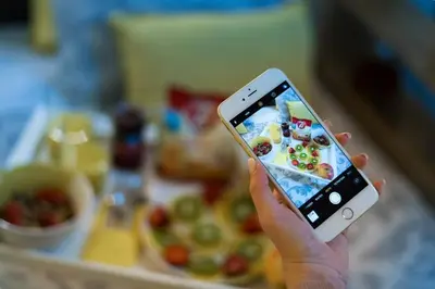 a person holding a cell phone in front of a tray of food at Jasmine Studio - at the heard of old town in Chania Town