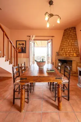 a dining room with a wooden table and chairs at Mountain View Villa, by the Pool,Aris in Próvarma