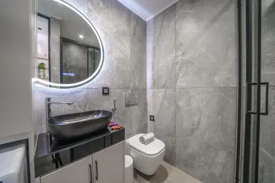 a bathroom with a sink and a toilet and a mirror at OLYMPIA Luxury Apartment in Chania Town