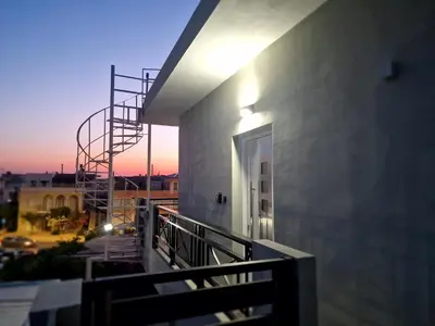 a balcony of a building with a sunset in the background at Thomas & Lukas Apartment in Chania Town