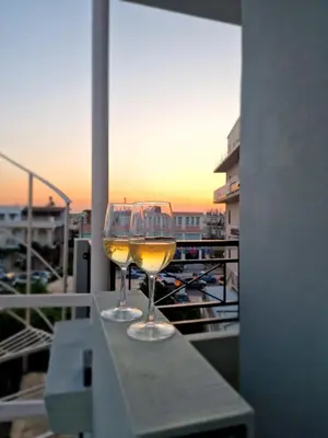 a glass of wine sitting on a table on a balcony at Thomas & Lukas Apartment in Chania Town