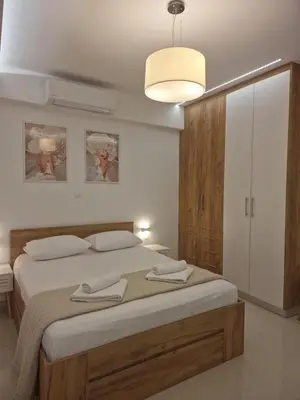 a bedroom with a large bed and a light fixture at Thomas & Lukas Apartment in Chania Town