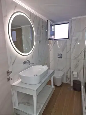 a white bathroom with a sink and a mirror at Thomas & Lukas Apartment in Chania Town