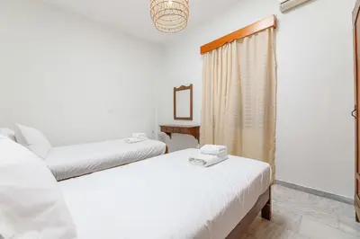 a room with two beds and a window at Lyria Hotel Apartments in Stalos