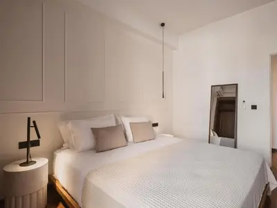 a white bedroom with a bed and a cross on it at Aeri Residence in Chania Town